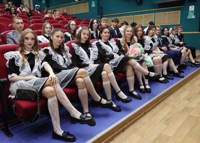 В зрительном зале собрались выпускники и выпускницы в традиционных праздничных нарядах